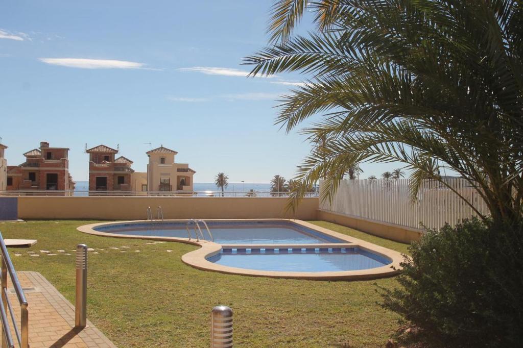 a swimming pool in a yard with a palm tree at Hydra Ground 1D in Puerto de Mazarrón