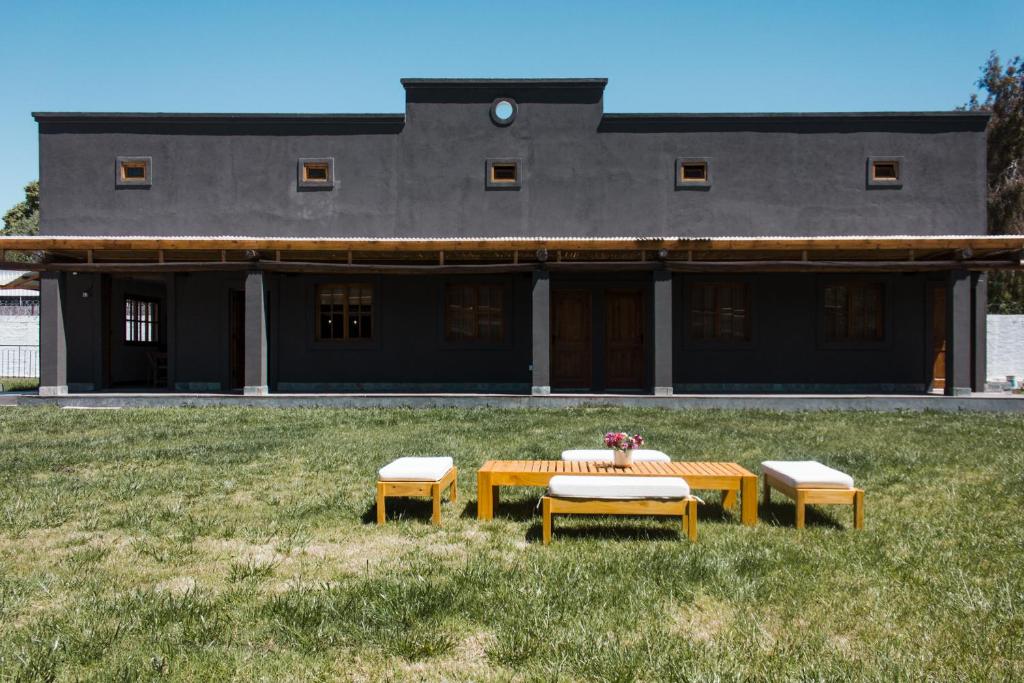 un tavolo e due panche di fronte a un edificio di El Fulgor - Posada - Chacras de Coria a Mayor Drumond
