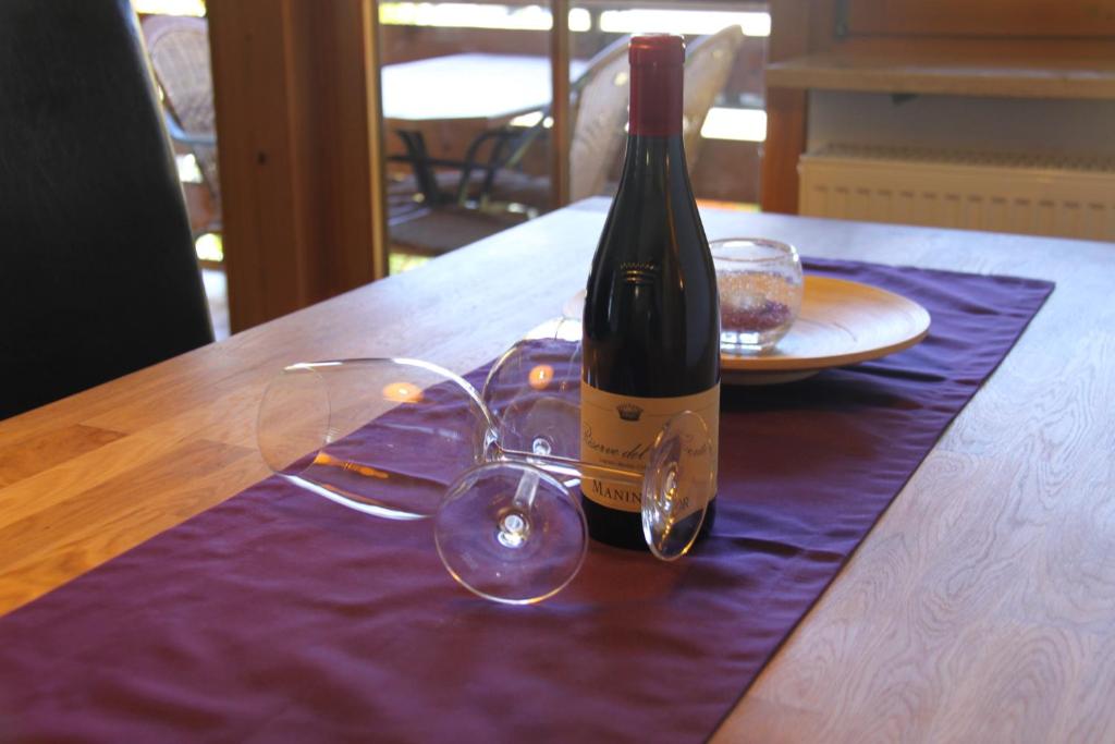 a bottle of wine and glasses on a table at Ferienwohnung Alpine Style in Oberstdorf