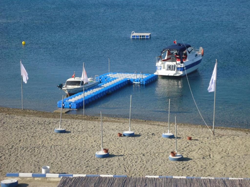 two boats are docked at a dock in the water at Bells Motel in Seferihisar