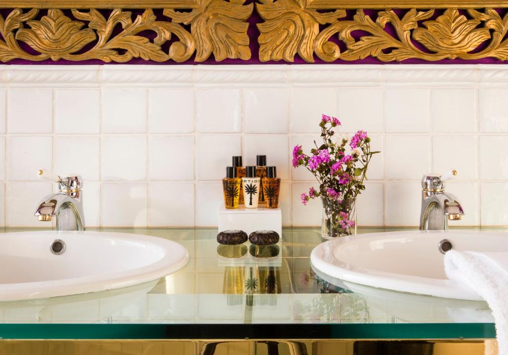 a bathroom with two sinks and a vase of flowers at Hotel Piccolo Sant'Andrea in Praiano