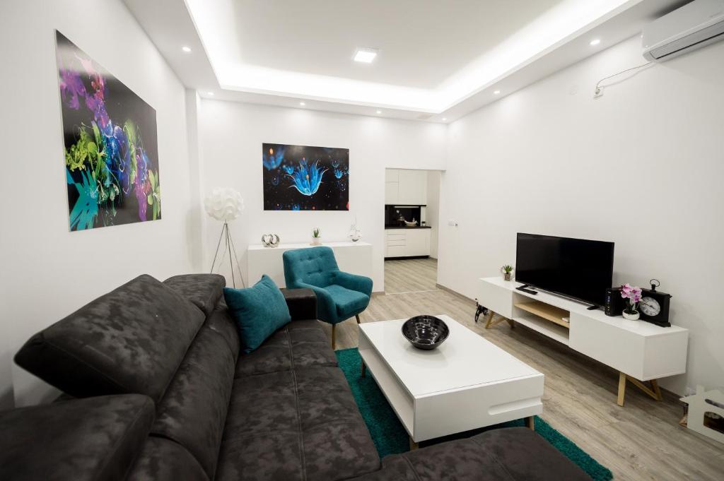 a living room with a couch and a tv at CENTAR Lux in Arandjelovac