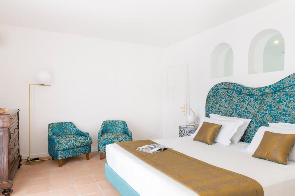 a bedroom with a bed and a chair at Hotel Piccolo Sant'Andrea in Praiano