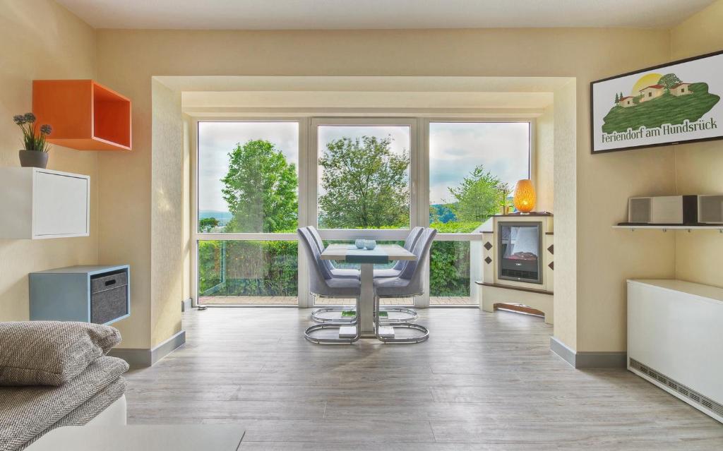 a living room with a table and chairs in front of a window at Feriendorf am Hundsrück in Floh