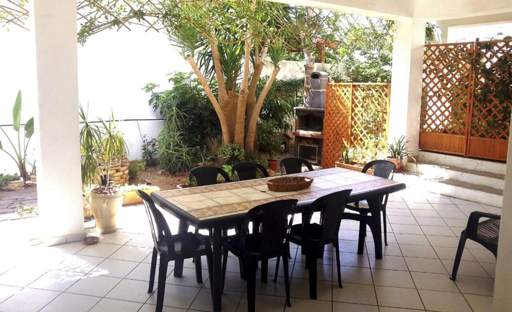 - une table et des chaises sur une terrasse avec un arbre dans l'établissement Matino Casa Vacanza, à Matino