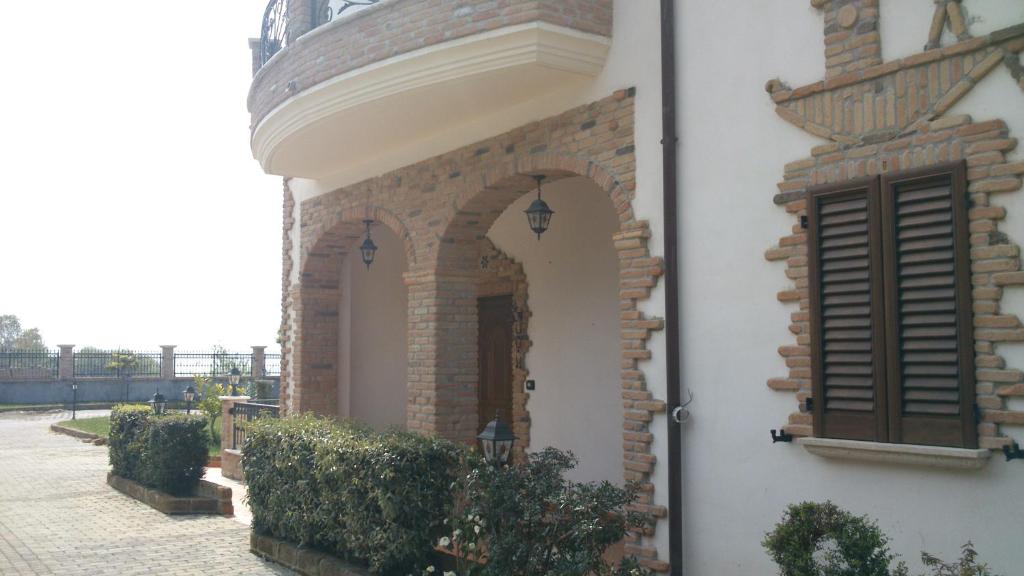 - un bâtiment en briques avec une fenêtre et un balcon dans l'établissement Appartamento in villa stile rustico, à Atri