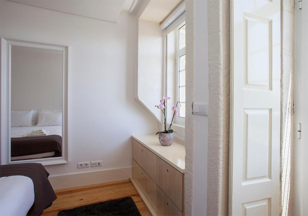 a bedroom with a mirror and a dresser with flowers on it at Liiiving in Porto | Central Secret Balcony in Porto