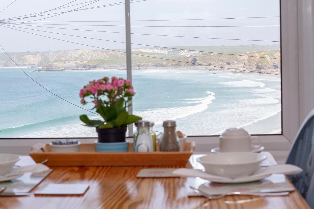 a table with a view of a beach from a window at Cliff House in Newquay