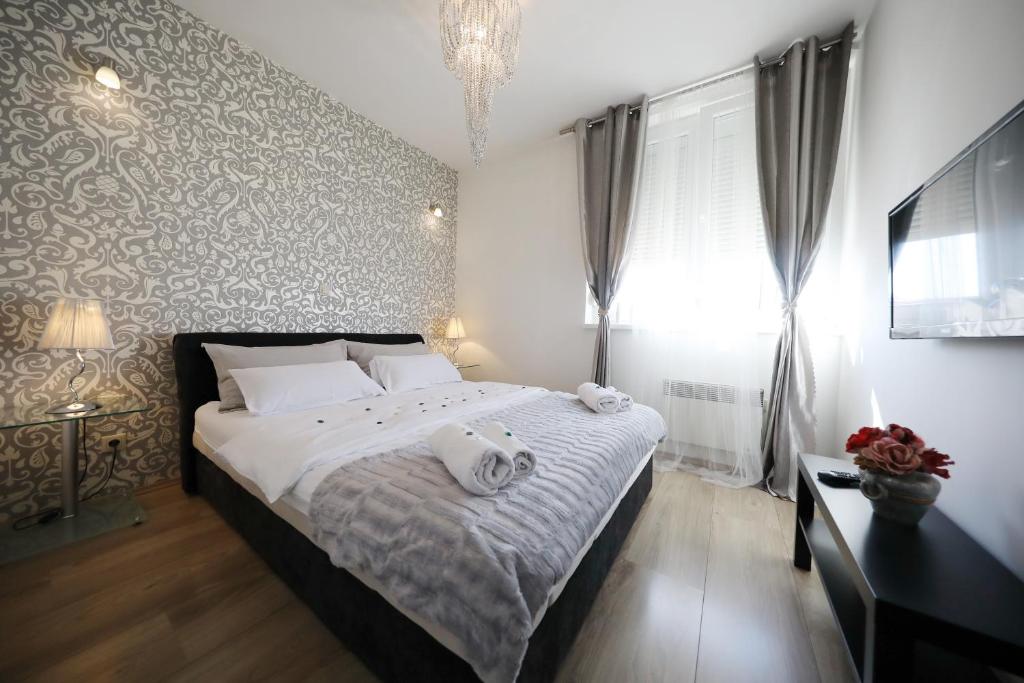 1 dormitorio con 1 cama con toallas en Top Apartments Zadar, en Zadar