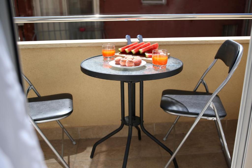 stół z napojami i talerzem jedzenia na nim w obiekcie Apartments & Rooms Andrea w mieście Zadar