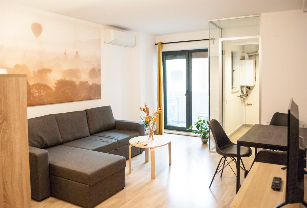 uma sala de estar com um sofá e uma mesa em Urban Nest Banu Manta em Bucareste