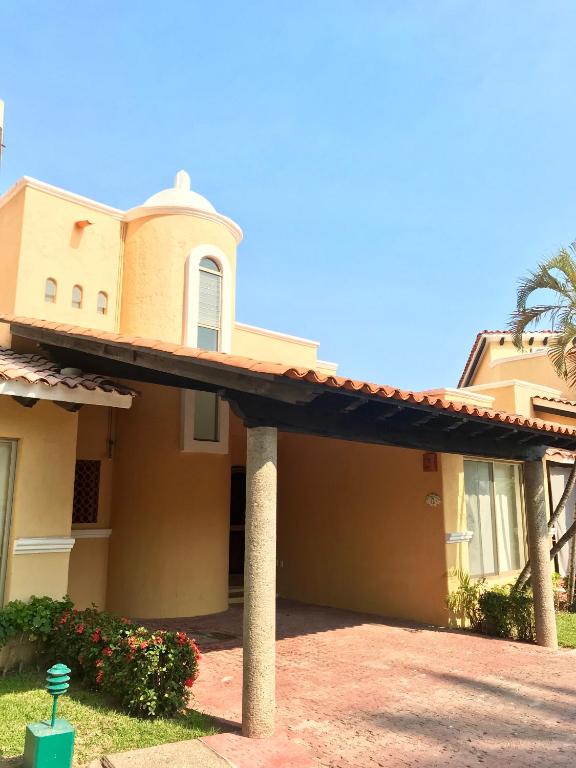 a house with a porch in front of it at Villa 18 Con Playa 3 Recamaras dentro de Hotel en Ixtapa in Ixtapa