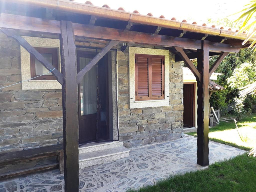 a stone house with a wooden pergola at Quinta da Moagem in Macedo de Cavaleiros