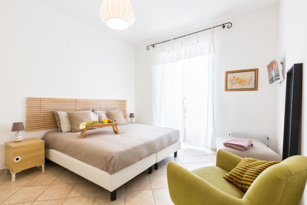 una camera bianca con un letto e una sedia di Explore the Amalfi Coast from a Cosy Home in Sorrento Centre a Sorrento