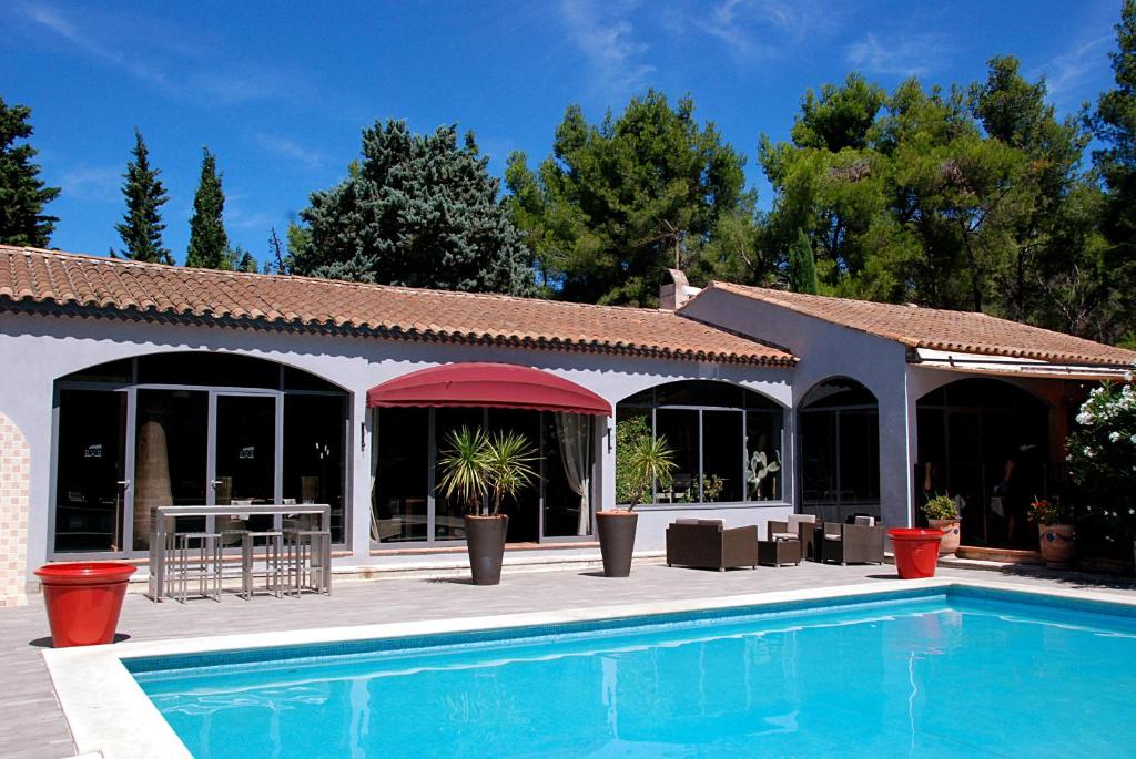 a resort with a swimming pool and a building at Hotel Les Mazets Des Roches in Tarascon