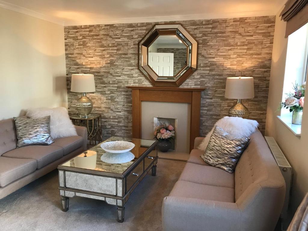 ein Wohnzimmer mit 2 Sofas und einem Kamin in der Unterkunft Brome House in Carterton