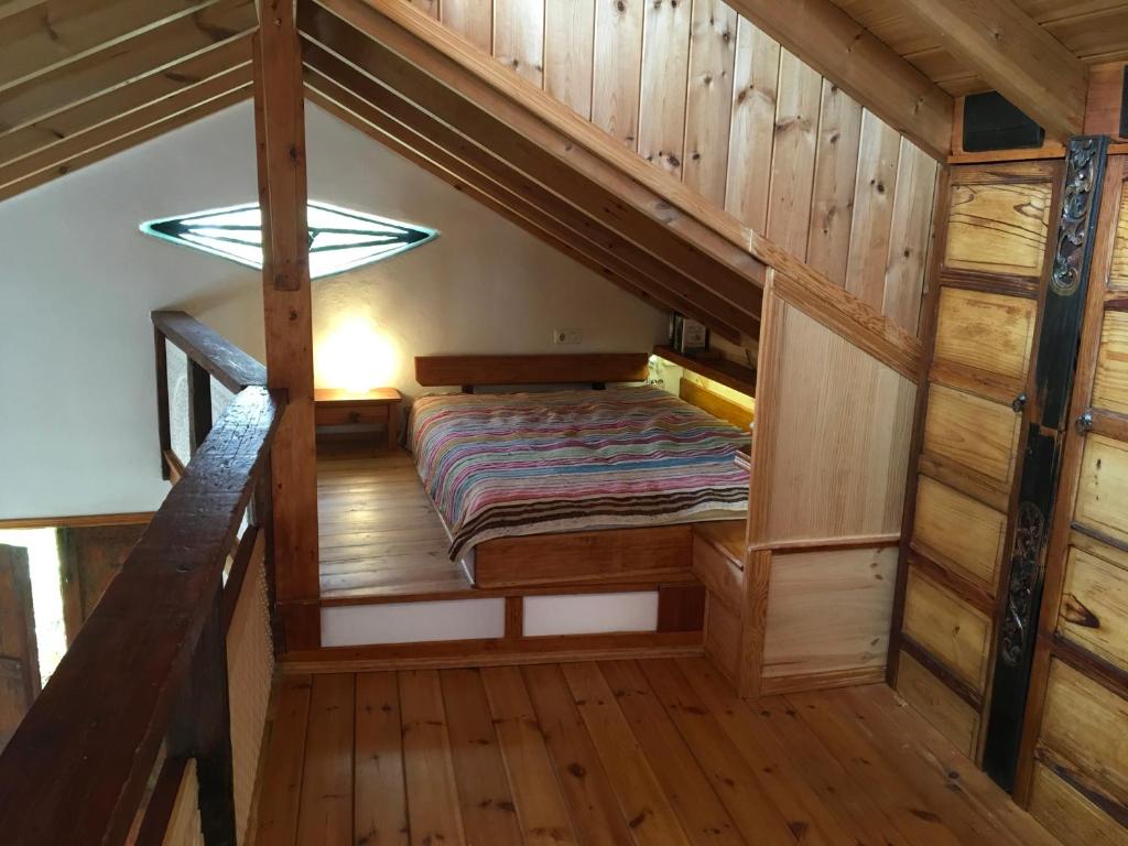 Łóżko w pokoju z drewnianymi ścianami i drewnianą podłogą w obiekcie Casa Ambiente w mieście Valle Gran Rey