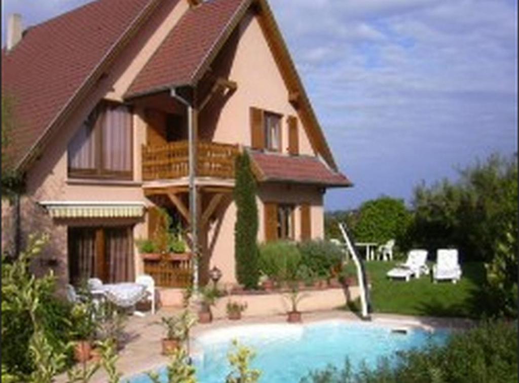 a house with a swimming pool in front of it at Vignoble in Bennwihr