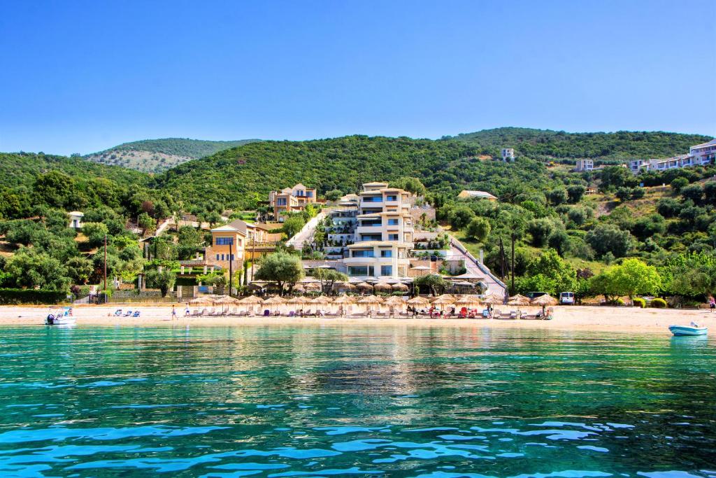 a beach with umbrellas and people on the beach at Prima Vista Boutique Hotel & Spa in Syvota