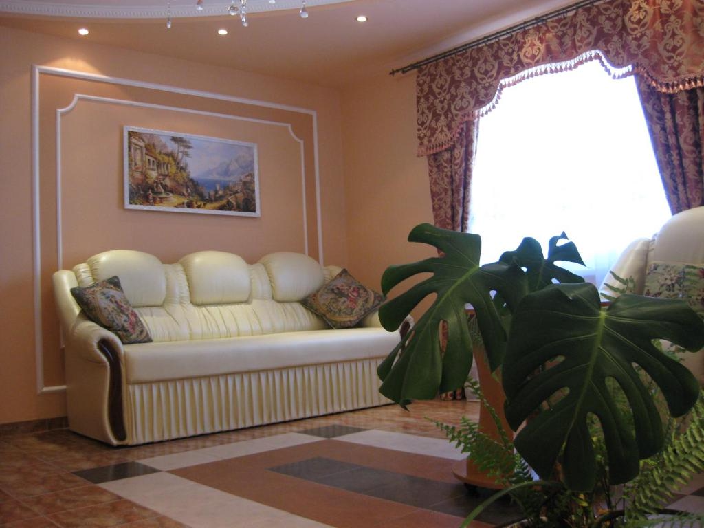 sala de estar con sofá blanco y ventana en Готель Алекс, en Lutsk