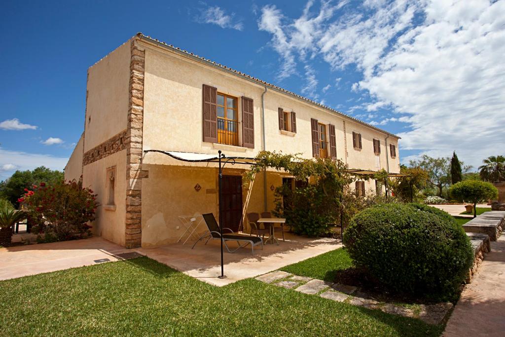 a building with a chair and a table in a yard at Agroturisme Na Martina in Portopetro
