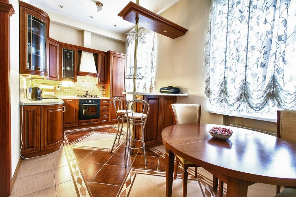 a kitchen with a wooden table and a dining room at Miracle Apartments on Smolensky Boulevard in Moscow