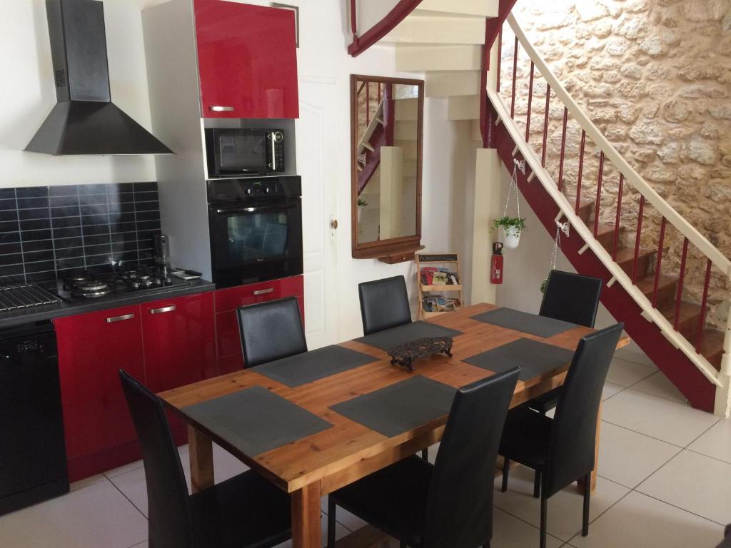 Bourg-sur-GirondeにあるMaison de Ville 8 personnesのキッチン(木製テーブル、椅子、階段付)