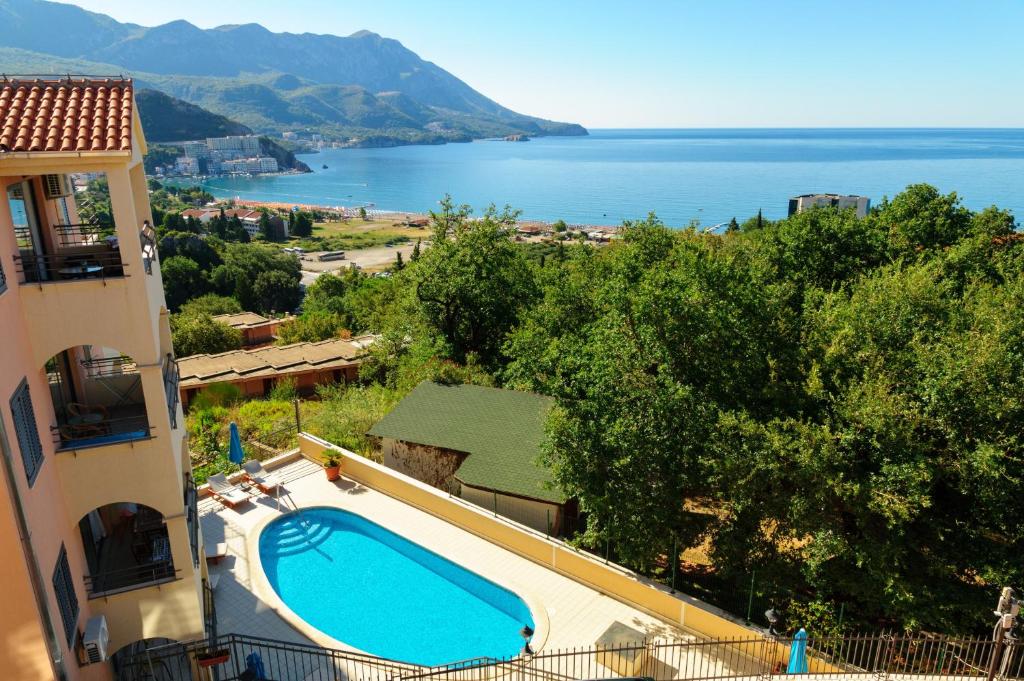 a swimming pool next to a building with a view of the ocean at Apartment with pool in Becici