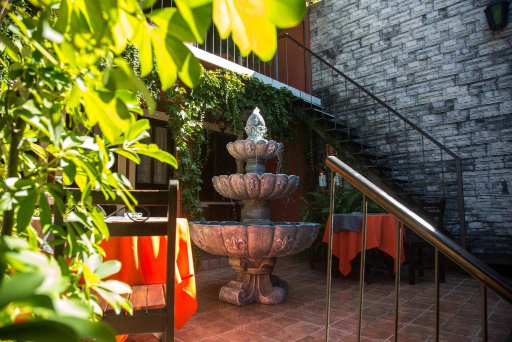 a large stone fountain sitting next to a staircase at Hotel Rivera in Colonia del Sacramento