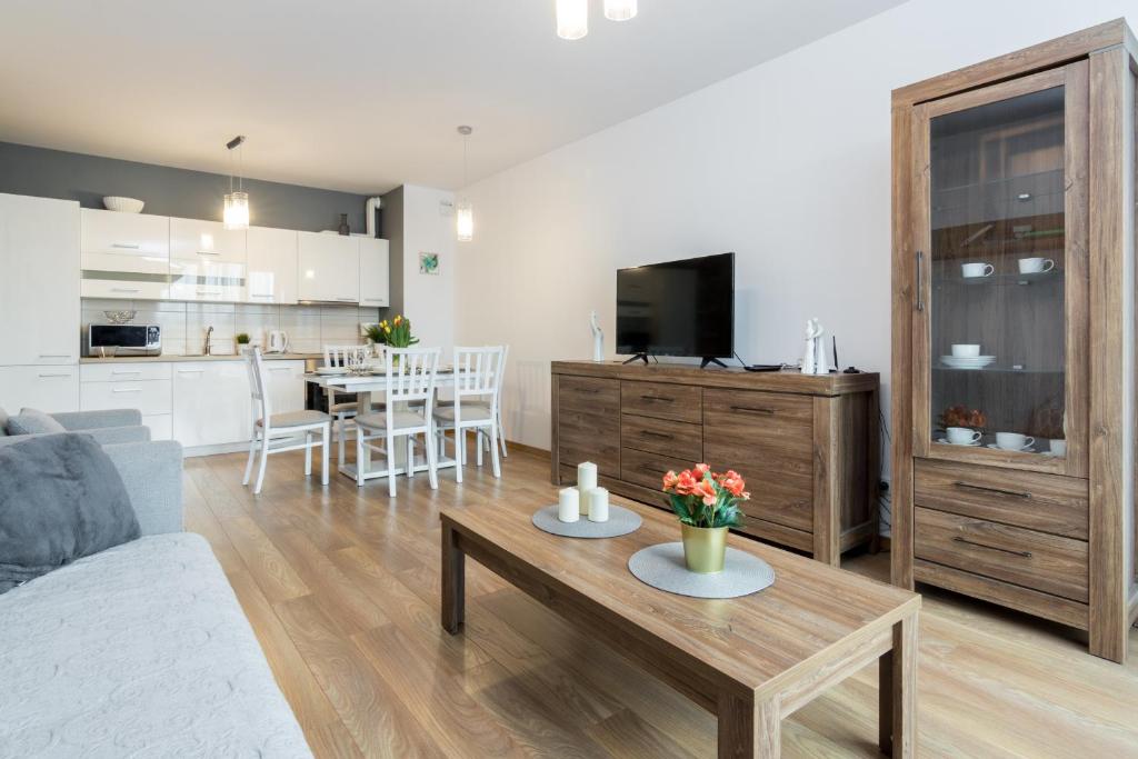 a living room with a couch and a table with flowers at Apartament Wawrzyńca in Krakow