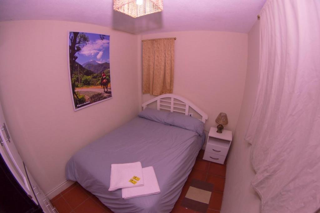 ein kleines Schlafzimmer mit einem Bett in einem Zimmer in der Unterkunft Samay Apart in Baños