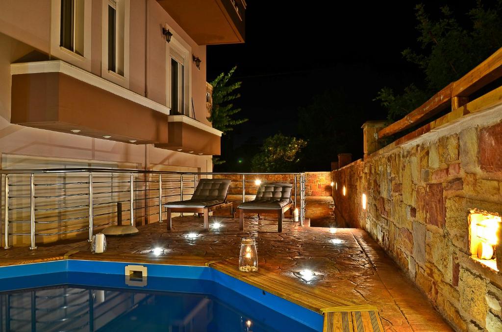 a patio with a swimming pool at night at Mastiha Villas in Town in Chios