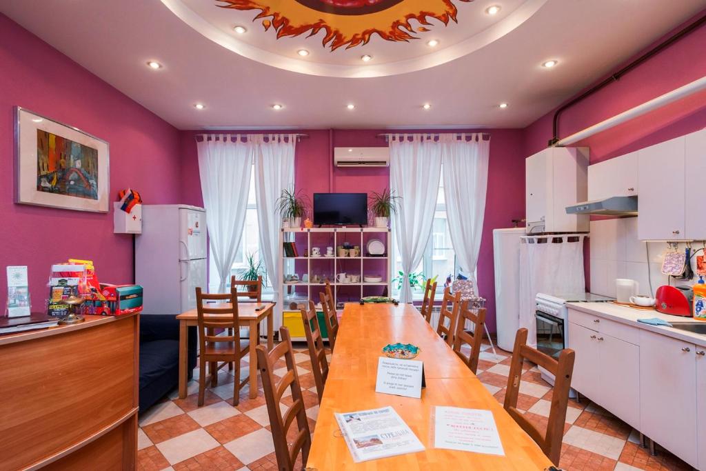 a kitchen and dining room with a long table and chairs at Итальянские комнаты Пио на канале Грибоедова 35 in Saint Petersburg