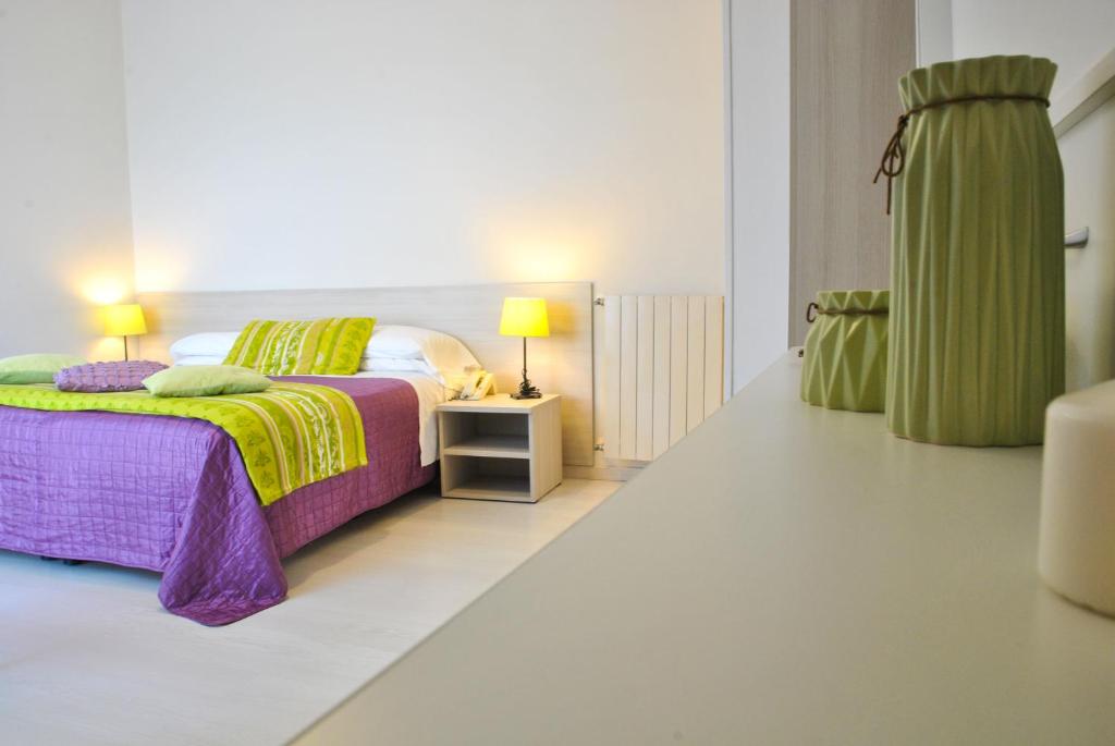 a bedroom with a bed with purple and yellow sheets at Hotel Villa Fiorita in Sorrento