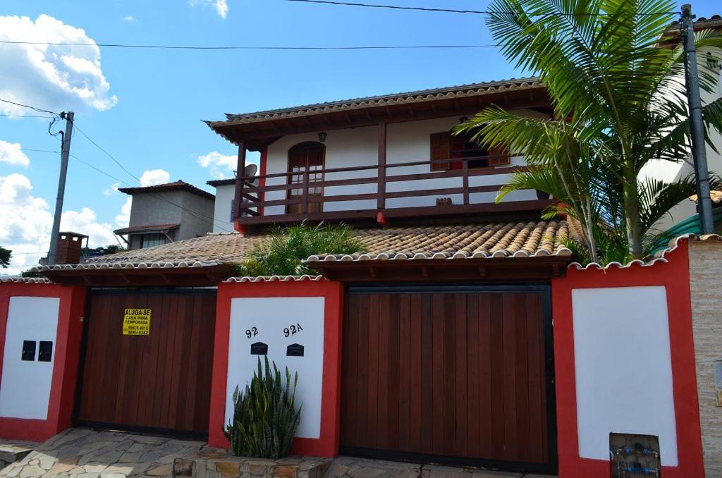 uma casa com portas de garagem vermelhas e brancas em Pouso Da Mari em Tiradentes