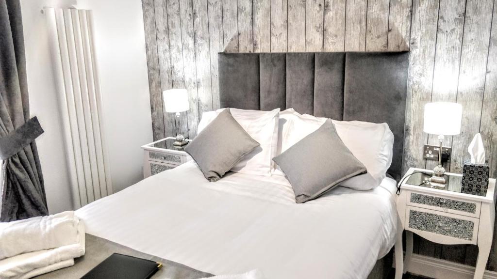 a bedroom with a white bed with a wooden wall at Number 4 in Derry Londonderry