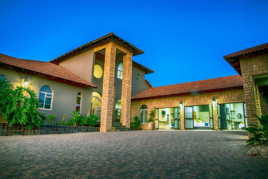 a large brick house with a driveway at Blue Rain Guest House in Bloemfontein