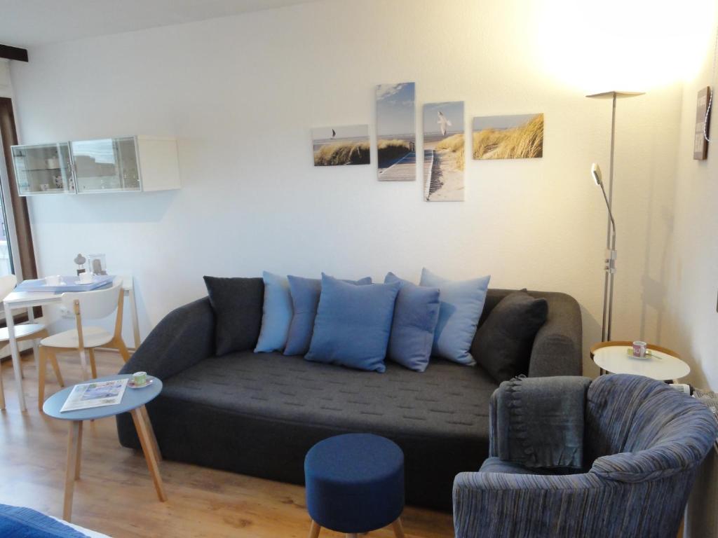 ein Wohnzimmer mit einem Sofa und einem Stuhl in der Unterkunft FeWo Piper in Grömitz