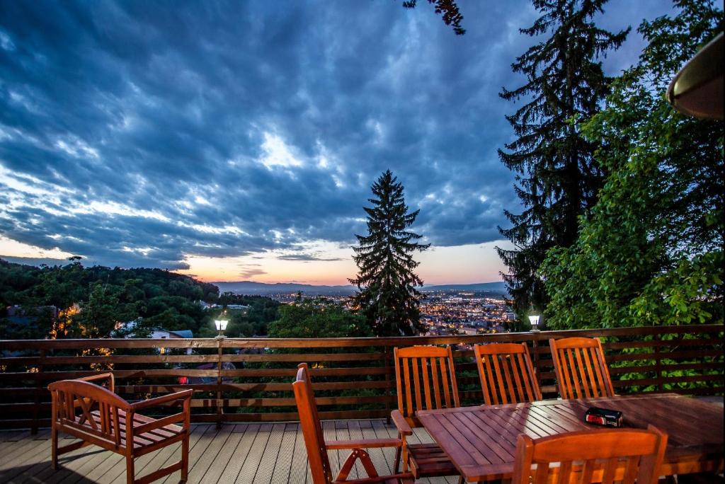 a table and chairs on a deck with a view at Splendor in the forest in Braşov