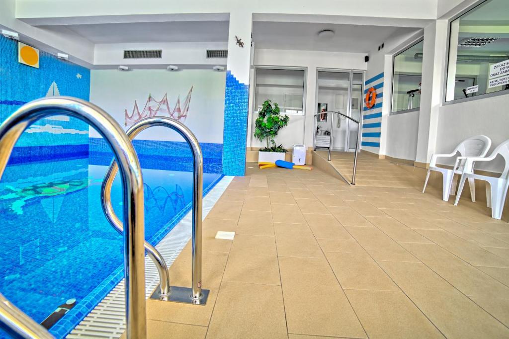 een zwembad in een kamer met een hal met stoelen bij Villa Medica in Rabka