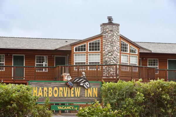 ein großes Holzhaus mit einem Schild davor in der Unterkunft Harborview Inn in Seward