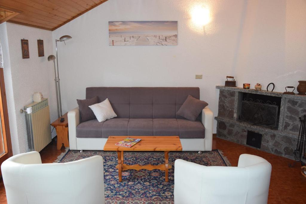 un soggiorno con divano e tavolo di Casa Maura ad Aprica