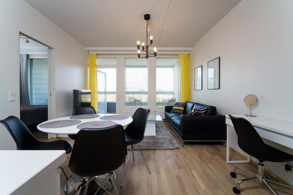 オウルにあるJHO Premium Apartmentsのリビングルーム(テーブル、椅子、ソファ付)