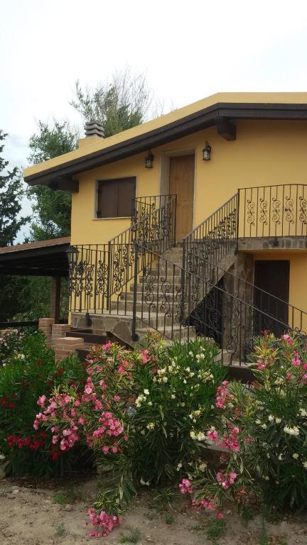 una casa amarilla con escaleras y flores delante en Rifugio della Pace, en Sant' Isidoro
