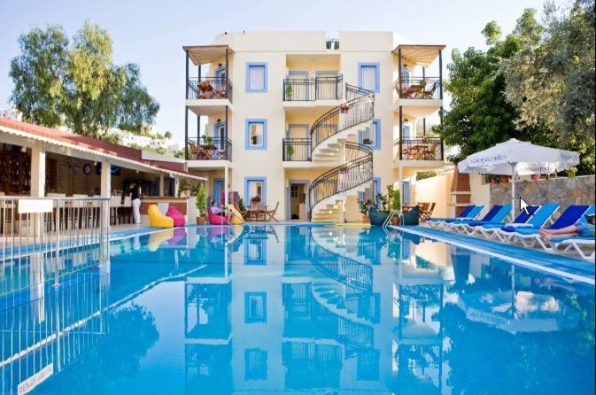 basen z krzesłami i hotel w obiekcie Merve Apartments, your home from home in central BODRUM, street cats frequent the property, not all apartments have balconies , ground floor have terrace with table and chairs w Bodrum