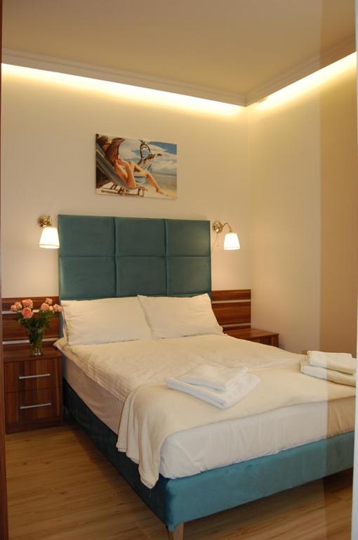 1 dormitorio con 1 cama grande y cabecero verde en Villa Star, en Międzyzdroje