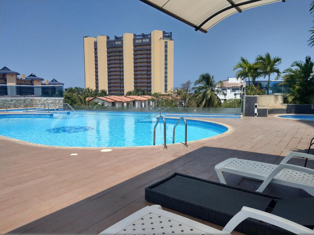 a swimming pool with chairs and a resort at Apto Bello Horizonte a 100 mts de la Playa in Santa Marta