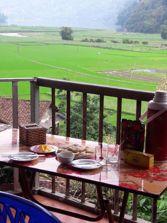 a table on a balcony with a view of a field at Ba Be Lake Homestay - Quynh Chi in Ba Be18