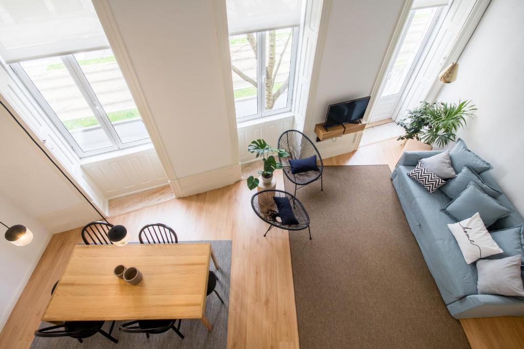 a living room with a blue couch and a table at Republica Apartments at D. Luis I Bridge in Vila Nova de Gaia