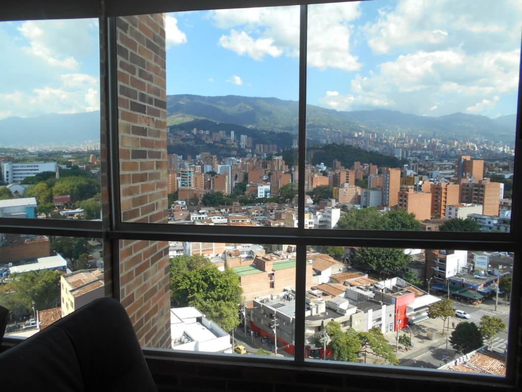 een raam met uitzicht op de stad bij Apartasuites AV in Medellín